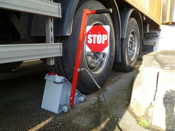 Cale roues en acier avec panneau stop pour sécuriser la remorque ou le véhicule à quai en cours de chargement ou déchargement