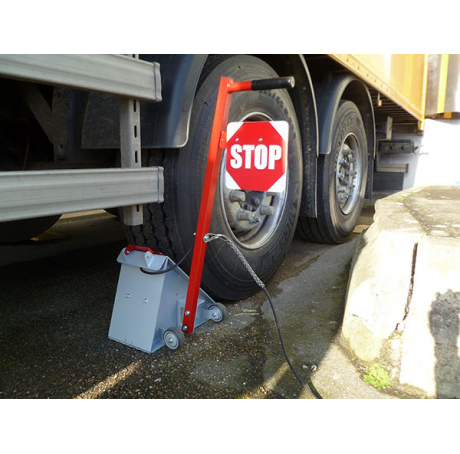La cale de roue avec panneau STOP et chaîne antivol pour camion